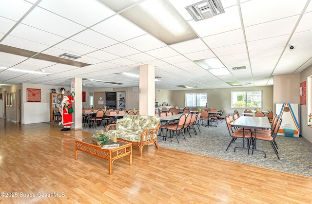 dining area with a paneled ceiling and hardwood / wood-style floors