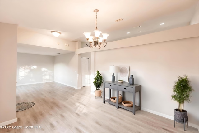 interior space with a chandelier and light hardwood / wood-style flooring