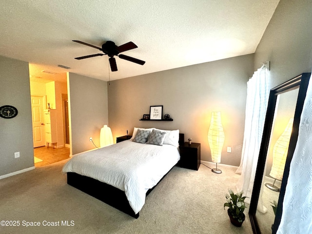 carpeted bedroom with a textured ceiling, connected bathroom, and ceiling fan