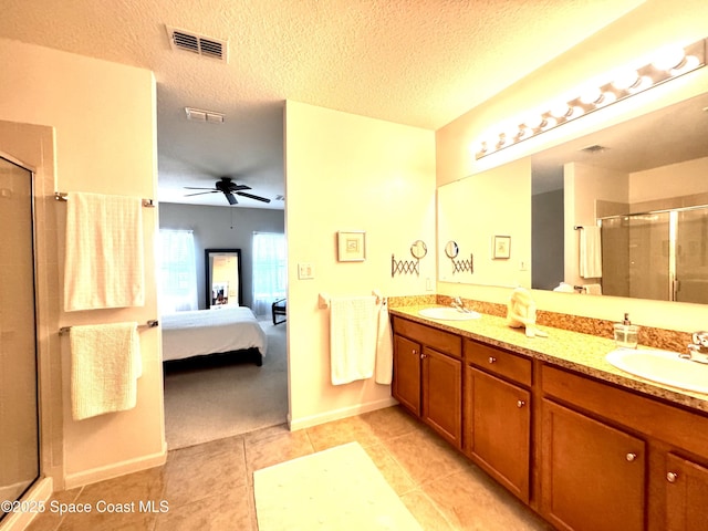 bathroom with vanity, a textured ceiling, tile patterned floors, and walk in shower