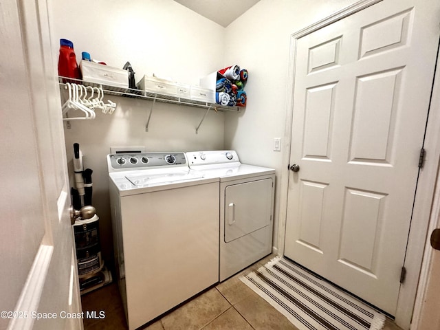 washroom featuring light tile patterned floors and washer and clothes dryer