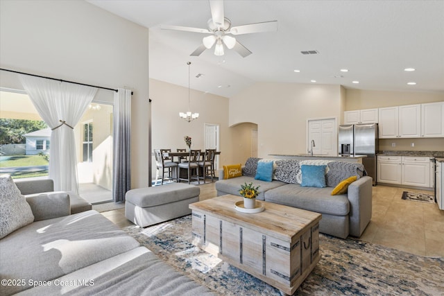 tiled living room featuring ceiling fan with notable chandelier, high vaulted ceiling, and sink