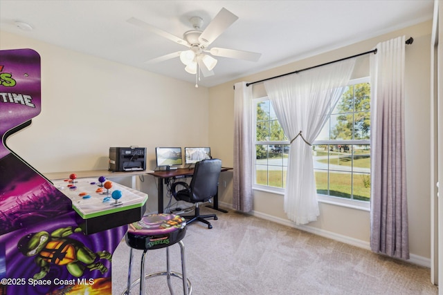 office featuring a healthy amount of sunlight, ceiling fan, and light carpet