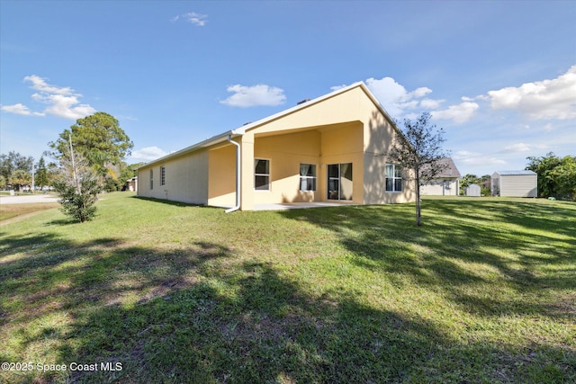 rear view of property featuring a lawn