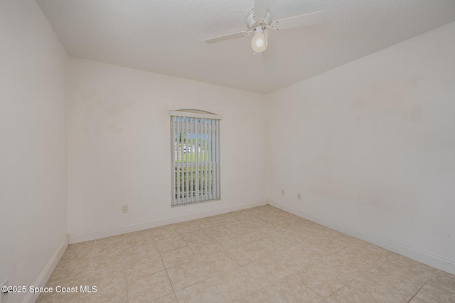 empty room featuring light tile patterned floors, a textured ceiling, and ceiling fan