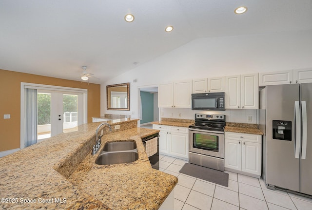 kitchen featuring light stone countertops, stainless steel appliances, vaulted ceiling, and white cabinetry