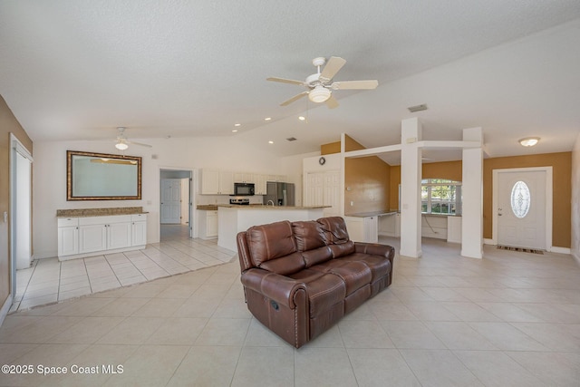 tiled living room featuring ceiling fan and lofted ceiling