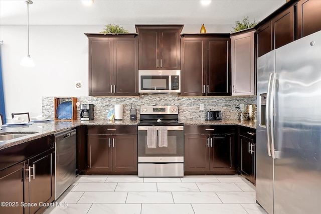 kitchen with light stone countertops, backsplash, dark brown cabinets, stainless steel appliances, and hanging light fixtures