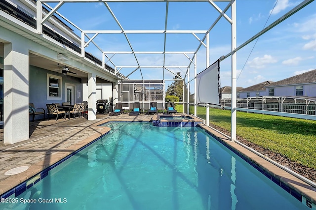 view of swimming pool with a lanai, a patio area, ceiling fan, and a yard