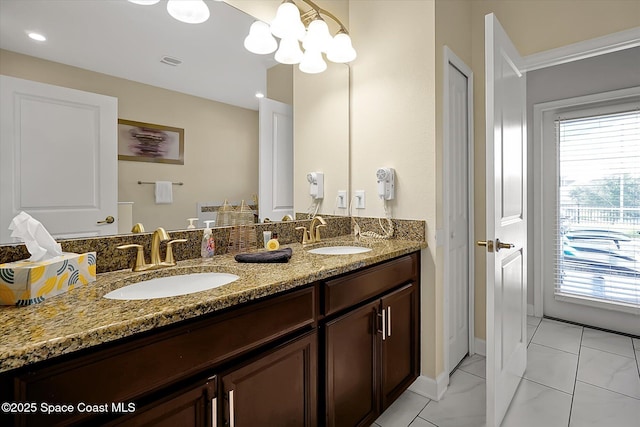 bathroom featuring plenty of natural light, vanity, and a notable chandelier