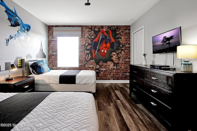 bedroom featuring dark hardwood / wood-style floors and brick wall