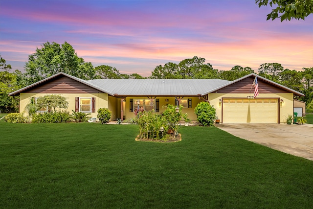 ranch-style house featuring a yard and a garage