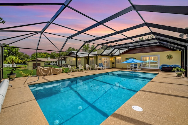 pool at dusk featuring a patio and a lanai