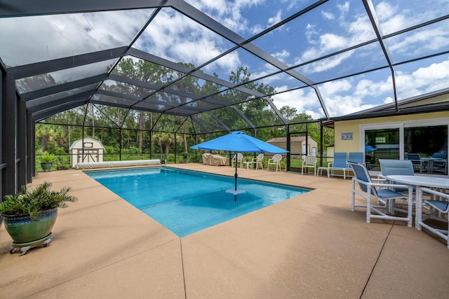 view of pool featuring a lanai, a patio area, and a shed