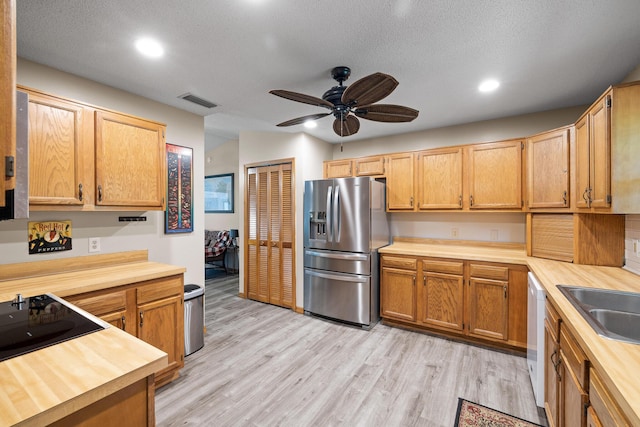 kitchen featuring white dishwasher, sink, light hardwood / wood-style flooring, ceiling fan, and stainless steel fridge