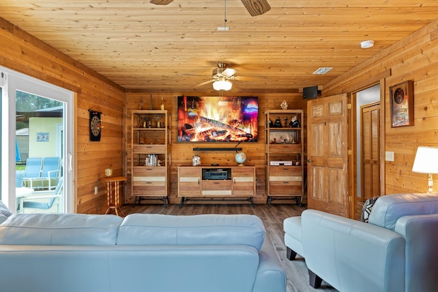 living room featuring ceiling fan, dark hardwood / wood-style flooring, wooden ceiling, and wooden walls