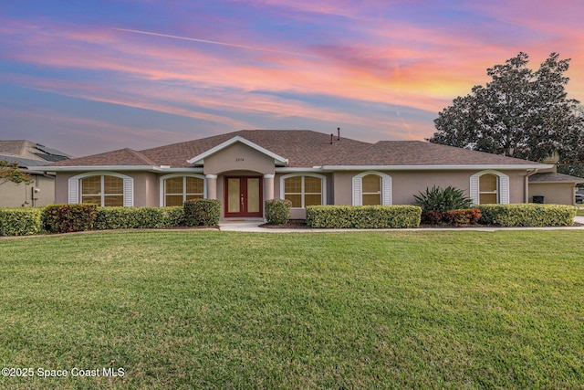 ranch-style house with a lawn and french doors