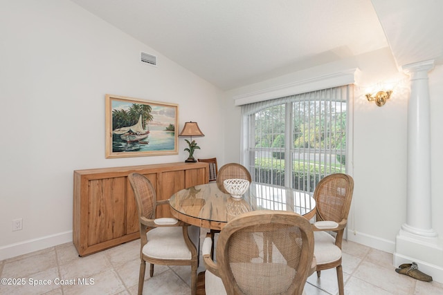 dining space with vaulted ceiling and ornate columns