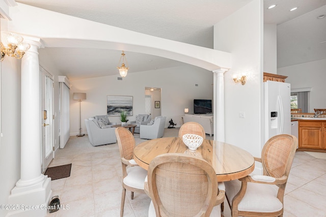 dining room with light tile patterned floors and vaulted ceiling