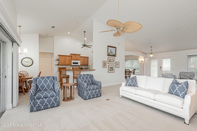 carpeted living room with high vaulted ceiling, ceiling fan, and a wealth of natural light