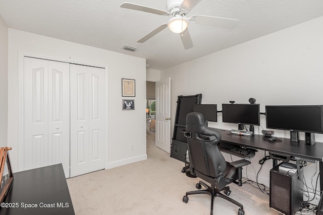 home office with a textured ceiling, light colored carpet, and ceiling fan