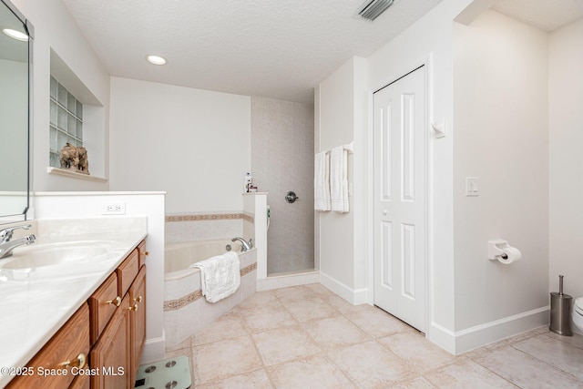 bathroom with a textured ceiling, vanity, shower with separate bathtub, and tile patterned floors