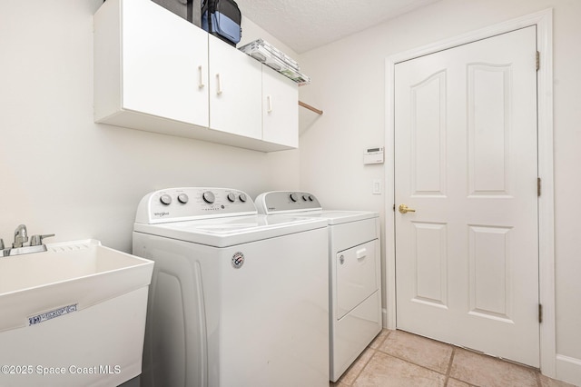 laundry room with washer and clothes dryer, cabinets, sink, and a textured ceiling