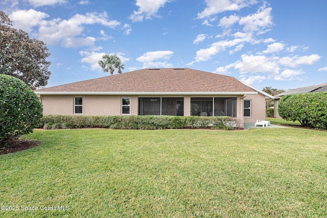 rear view of house with a sunroom and a yard