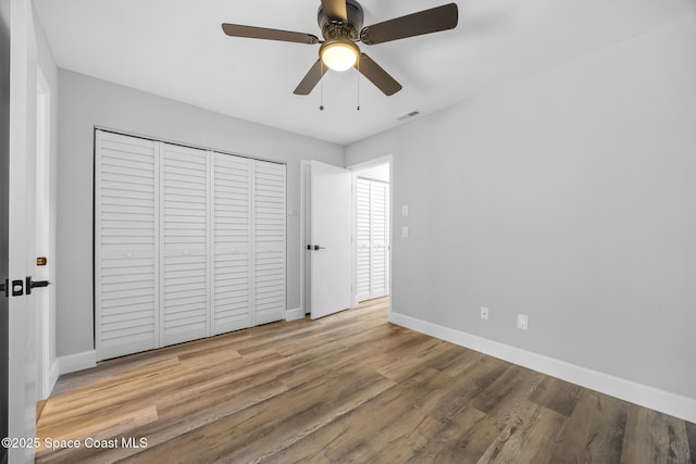 unfurnished bedroom featuring a closet, ceiling fan, and wood-type flooring