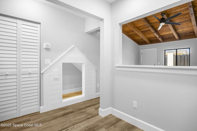 interior space featuring ceiling fan, vaulted ceiling with beams, wood-type flooring, and wooden ceiling