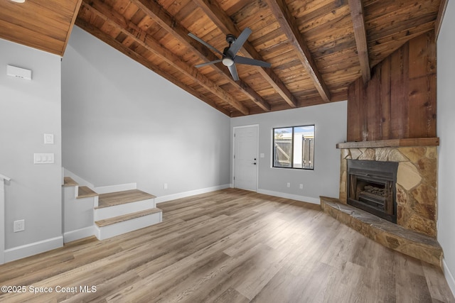 unfurnished living room with light hardwood / wood-style flooring, vaulted ceiling with beams, ceiling fan, wood ceiling, and a fireplace