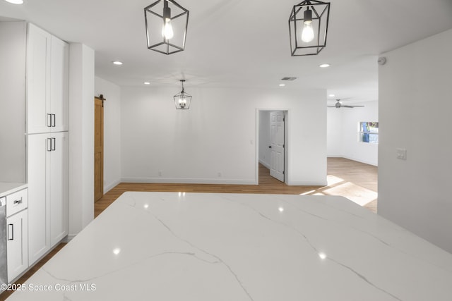 corridor featuring a barn door and light hardwood / wood-style floors