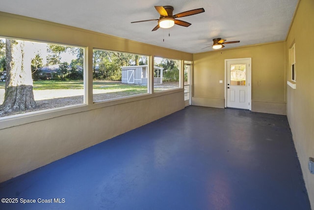 unfurnished sunroom featuring ceiling fan