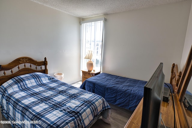 bedroom with hardwood / wood-style floors and a textured ceiling