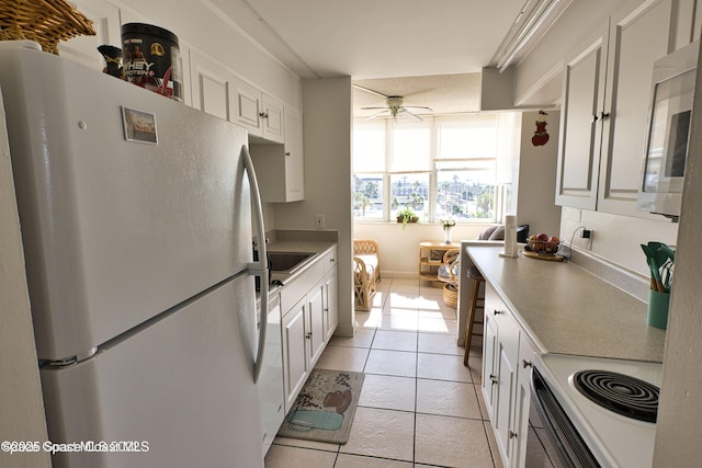 kitchen featuring ceiling fan, white cabinets, stainless steel appliances, and light tile patterned floors