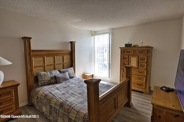 bedroom with hardwood / wood-style floors and a textured ceiling