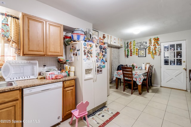 kitchen with decorative backsplash, light tile patterned floors, and white appliances