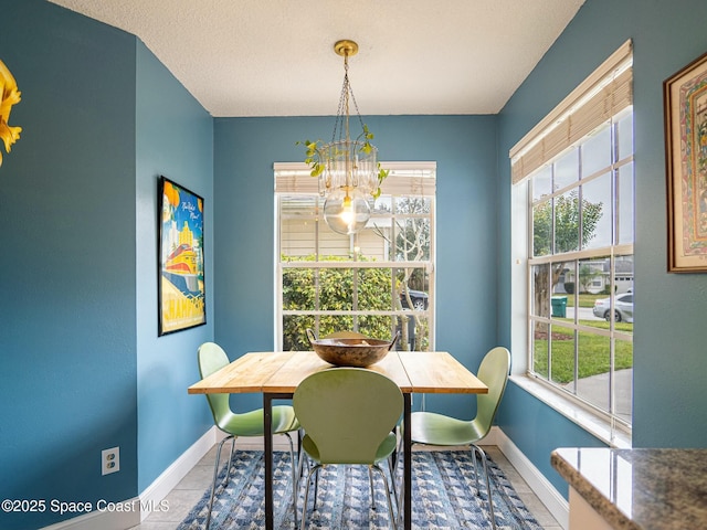 tiled dining room with a textured ceiling and an inviting chandelier