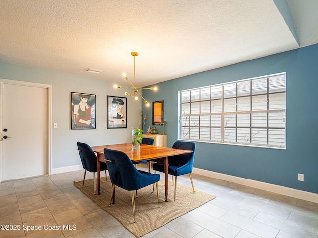 dining space featuring light tile patterned floors, a textured ceiling, an inviting chandelier, and a wealth of natural light