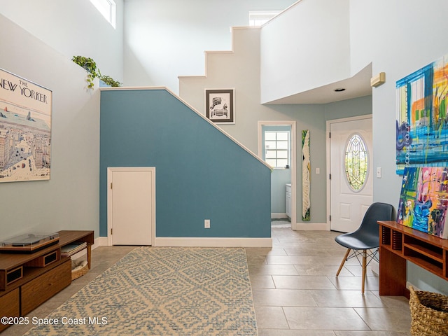 entrance foyer with tile patterned flooring and a towering ceiling