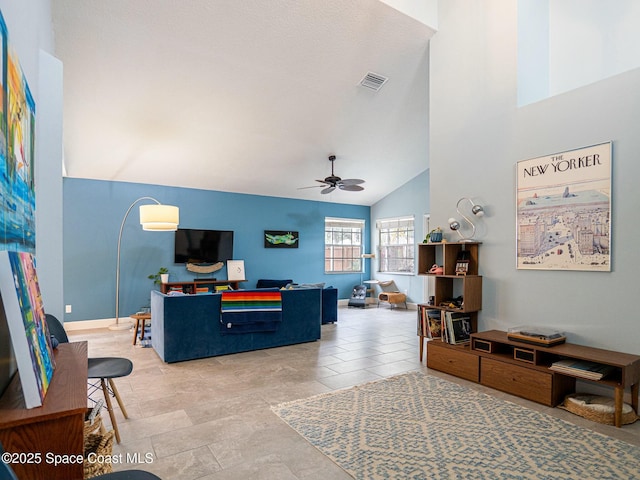 tiled living room featuring ceiling fan and high vaulted ceiling