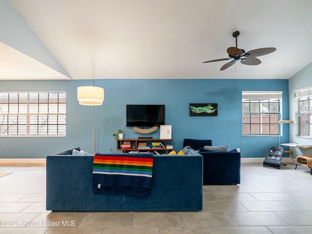 living room featuring ceiling fan, tile patterned flooring, and vaulted ceiling