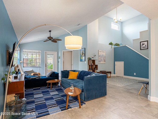 living room featuring ceiling fan with notable chandelier and lofted ceiling