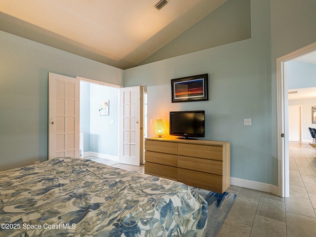 tiled bedroom featuring french doors and high vaulted ceiling