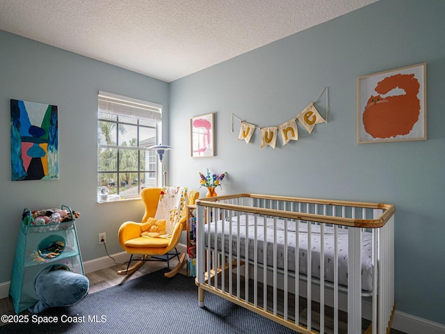 bedroom with a textured ceiling and a nursery area