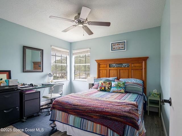 bedroom with ceiling fan and a textured ceiling