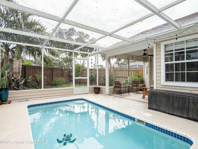 view of pool featuring glass enclosure and a patio