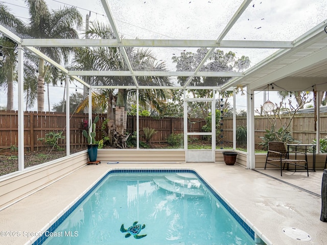 view of swimming pool featuring a lanai and a patio