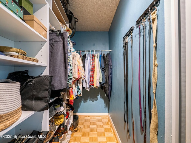 walk in closet with parquet flooring