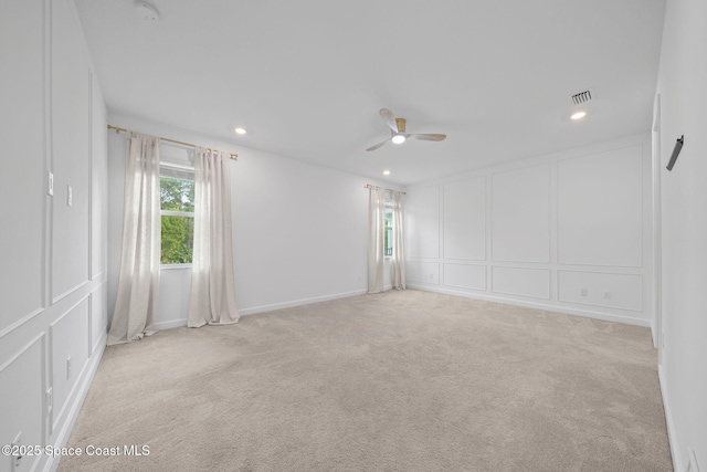 carpeted spare room with ceiling fan